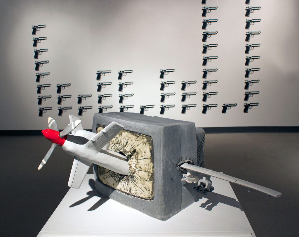 student exhibition with ceramic missile crashing through a TV